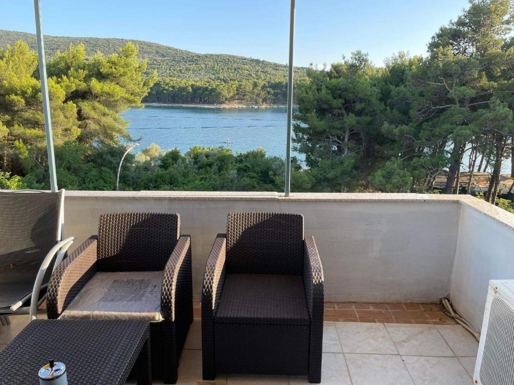 a balcony with chairs and a view of the water at apartman FML Cres in Cres