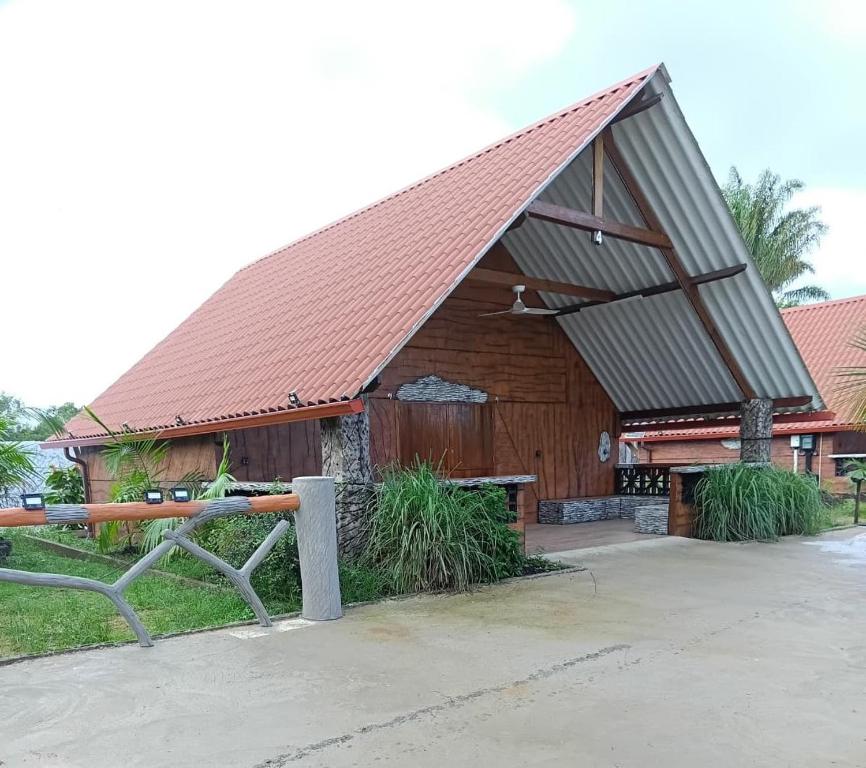 a large wooden building with a pitched roof at CHALET - SCEA 2222 Site Agrotouristique in Sinnamary