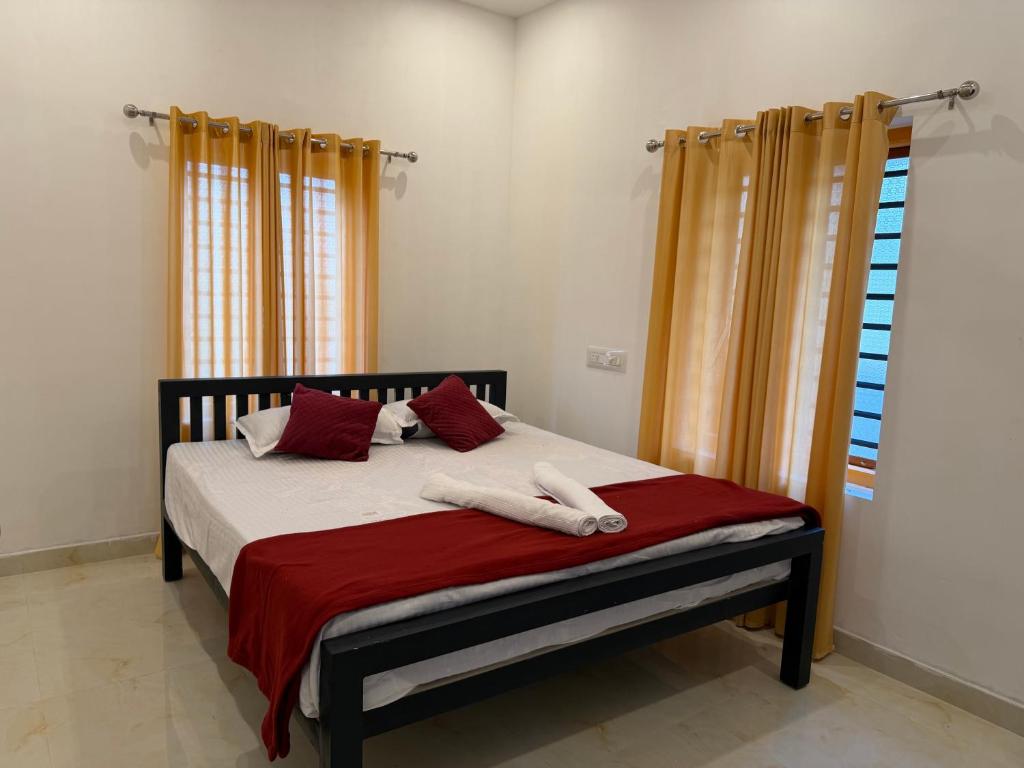 a bedroom with a bed with two towels on it at ACK River Palms - Athirappilly in Athirappilly