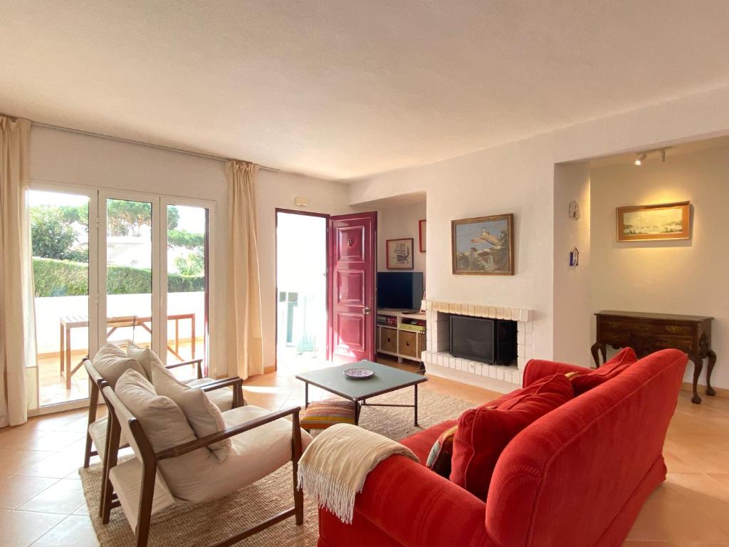 a living room with a red couch and chairs at Casa Manacá Vilamoura in Quarteira