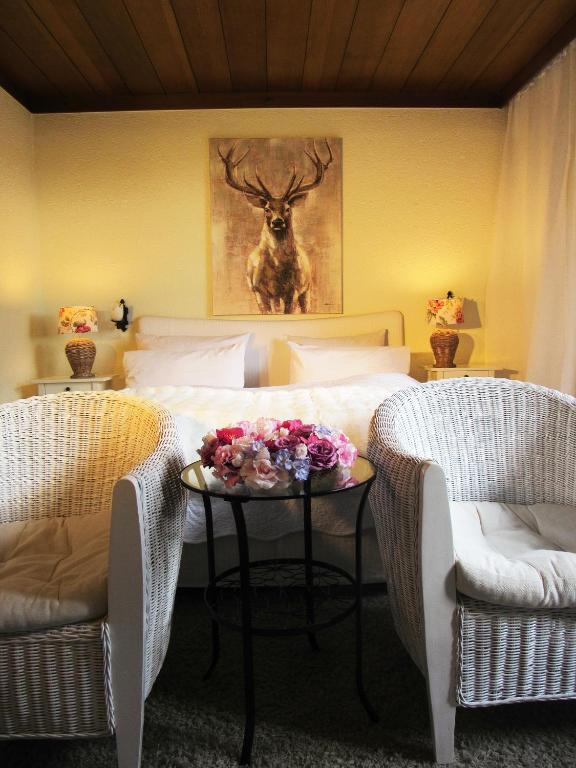 a bedroom with a bed with a table with flowers on it at Schwarzberghof in Dachau