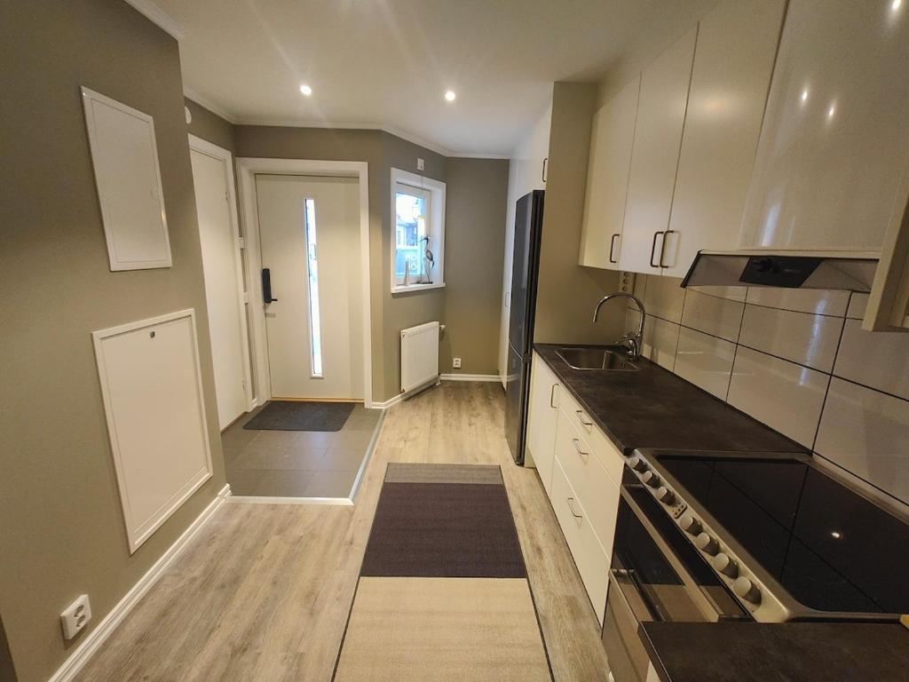 a kitchen with white cabinets and a black counter top at New Central Apartment in Östhammar