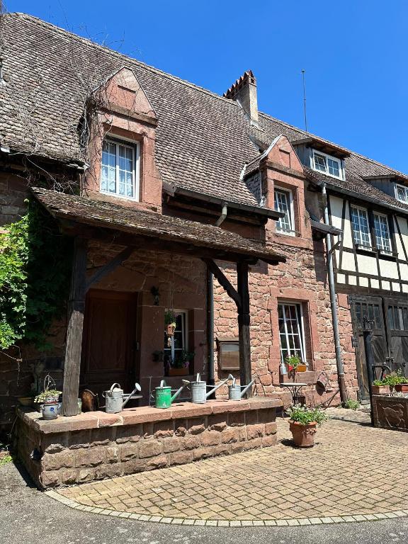 an old brick house with a patio in front of it at Ferme Mellon in Niederbronn-les-Bains