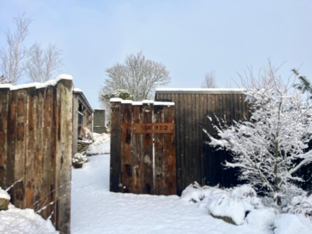 a fence in the snow with snow on it at Square 32 Luxury Shipping container in Knockcloghrim