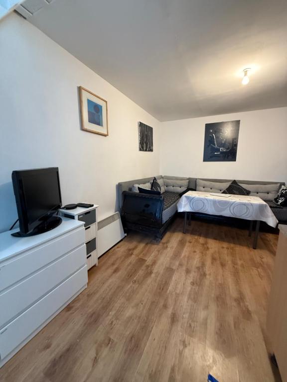 a living room with a bed and a flat screen tv at Duplex proche aéroport CDG et Paris in Sarcelles