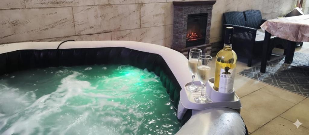 a hot tub with a bottle of wine and glasses at Спа къща Нико in Elkhovo