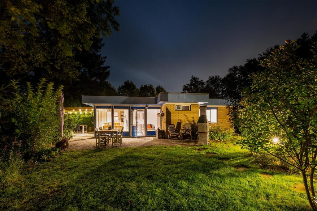 a yellow house with a garden at night at BlauweBoshuis in Koekange