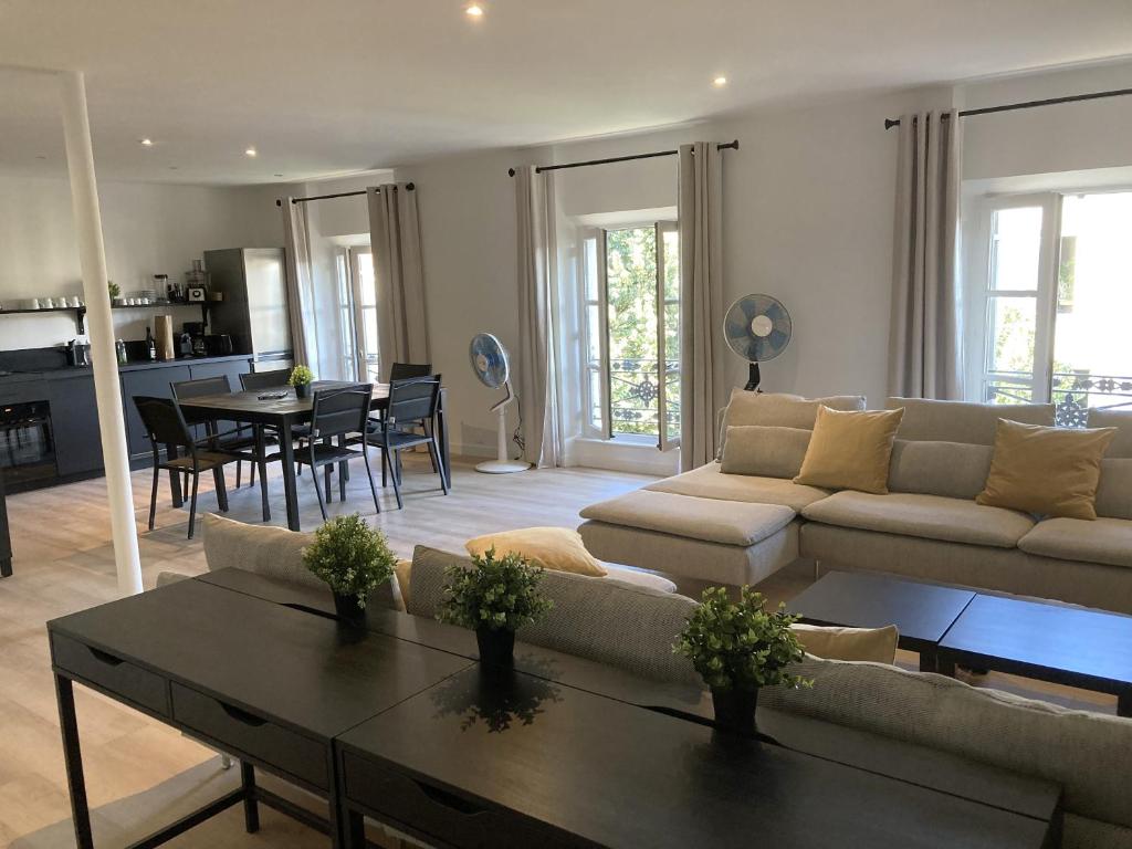 a living room with a couch and a table at Le Patio de l'Isle 2nd Duplex in Périgueux