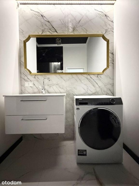 ein Badezimmer mit Waschmaschine und Spiegel in der Unterkunft Glamour Point in Reda
