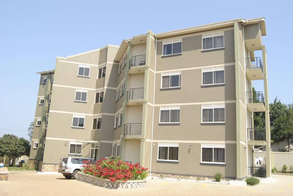 an apartment building with a car parked in front of it at Mukisa Apartments in Kampala