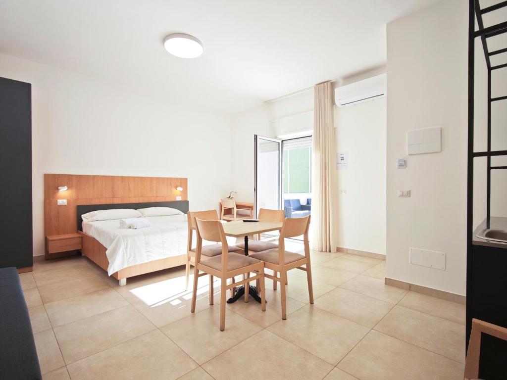 a bedroom with a bed and a table and chairs at Estelle in Bari