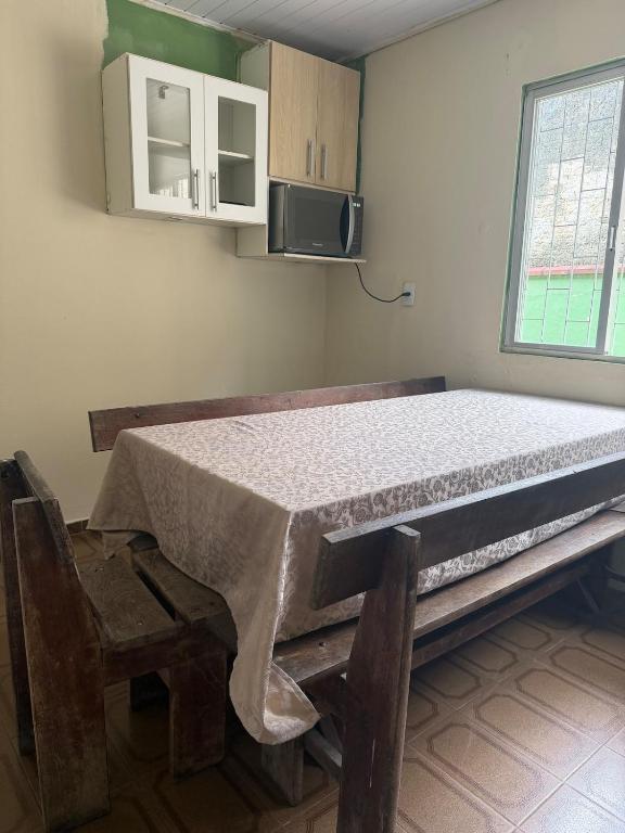 a bed in a room with a chair and a table at Casa de temporada in Camboriú