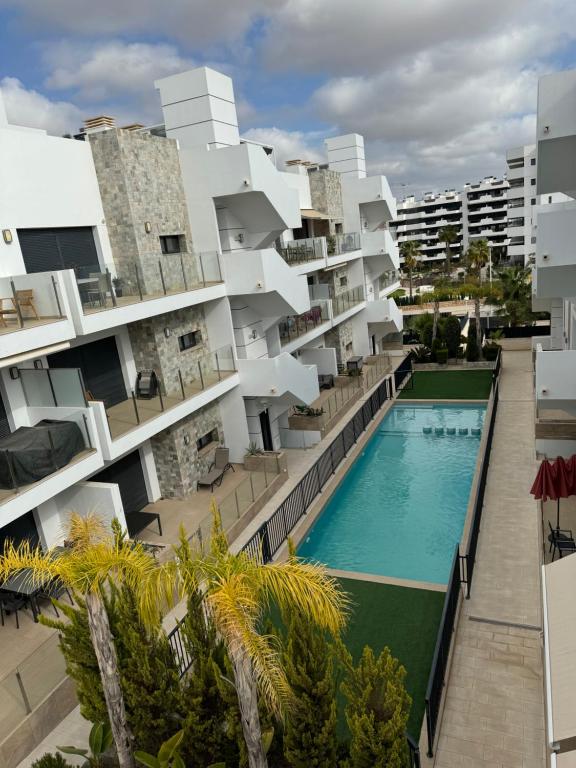 an apartment building with a swimming pool and palm trees at Sunny rest at Pedro's by PORT Holiday Rental in Arenales del Sol