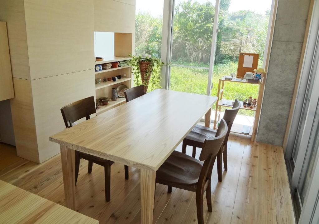 a dining room with a wooden table and chairs at Asahinoyado Shidakaji in Nanjo