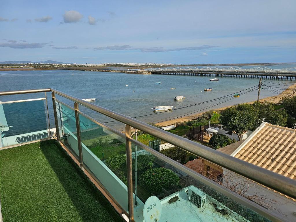 a balcony with a view of a river and a bridge at Blife Charlya private rooms at Faro beach in FAO