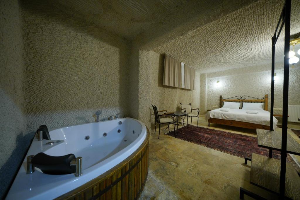 a large bathroom with a tub and a bedroom at Nirvana Cave House in Avcılar