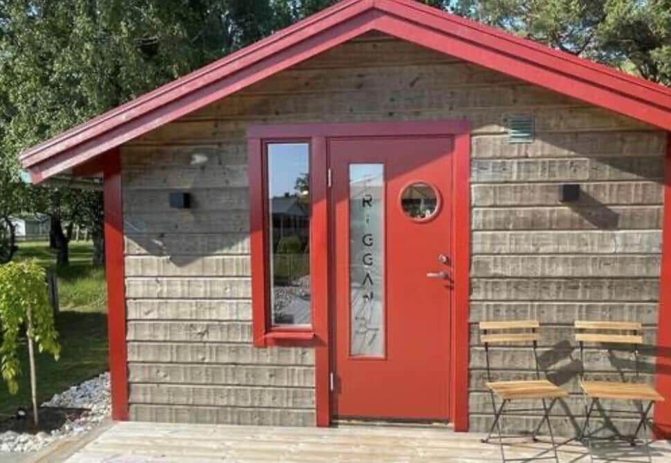 a smallshed with a red door and a table and chairs at HAL908-Skummesloevsstrand-Rundan-37 in Skummeslövsstrand