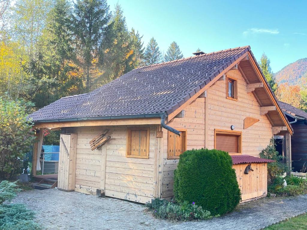 a wooden building with a garage in a yard at Chalet 6p Confort - Le chevreuil in Verchaix