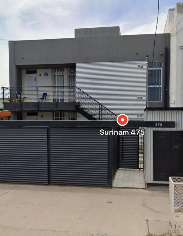 a building with a garage door with a gate at Deptosuno in General Roca