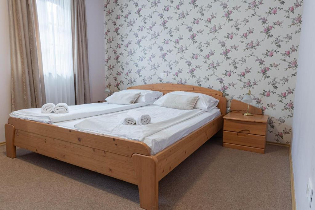 a bedroom with a wooden bed with towels on it at Martinov Hram in Bovec
