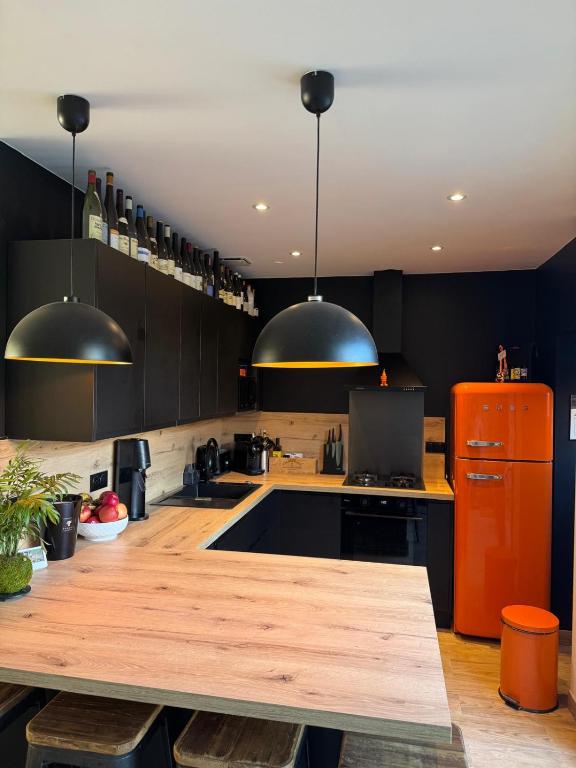 a kitchen with black cabinets and a wooden counter top at Reve dOpale in Étaples