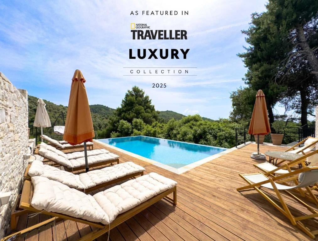 a pool with lounge chairs and umbrellas on a wooden deck at Damari Luxury 3 Bedroom Villas with Private Pool, Skiathos in Skiathos