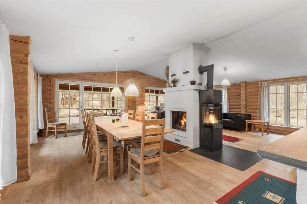 a kitchen and dining room with a table and a fireplace at HA398-Saeby-Kulmulevej-9 in Lyngså