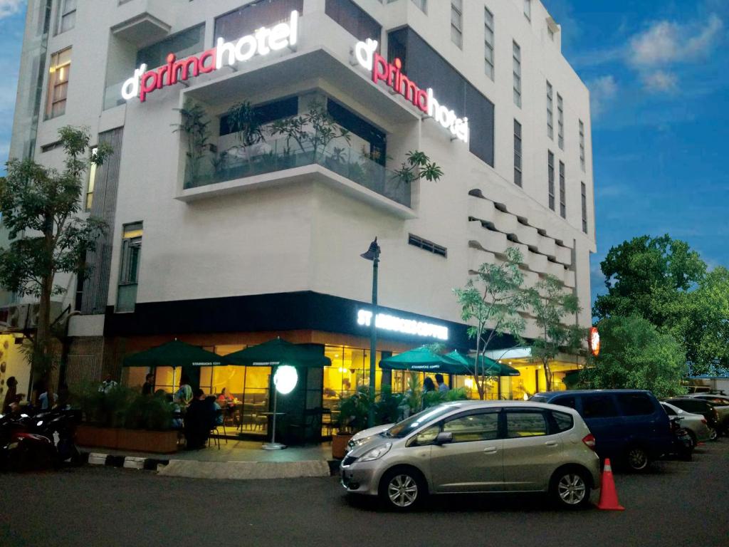 ジャカルタにあるd'primahotel Melawai - Blok Mの建物の前に駐車された車