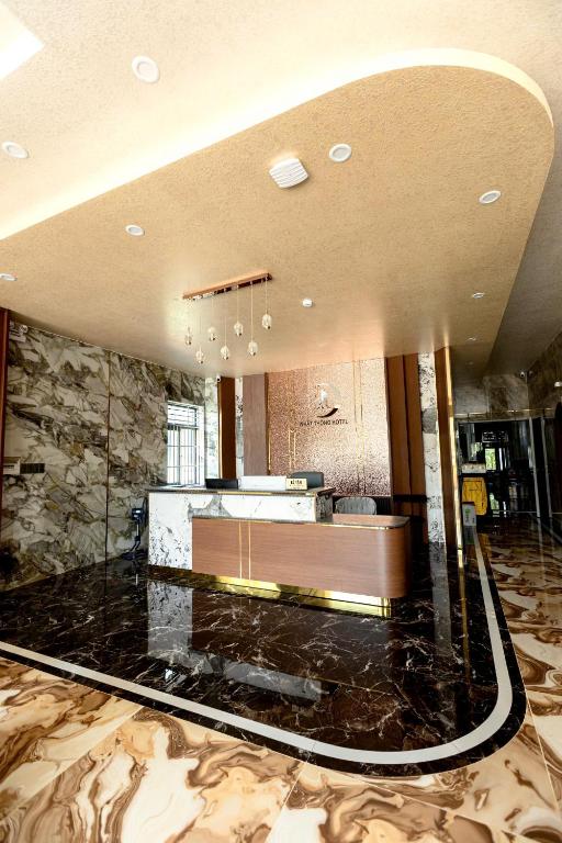 a lobby with a reception desk and a stone wall at Nhất Thống Hotel in Cao Lãnh