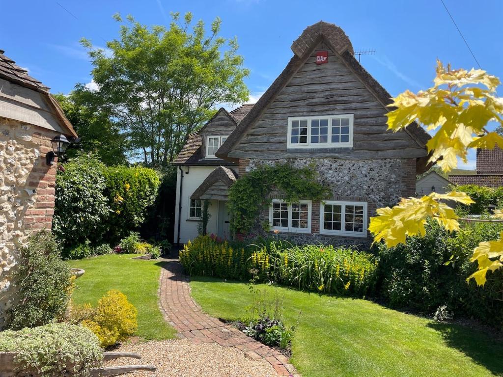 an old house with a garden in front of it at Thatch Cottage Singleton 2 miles from Goodwood in Singleton