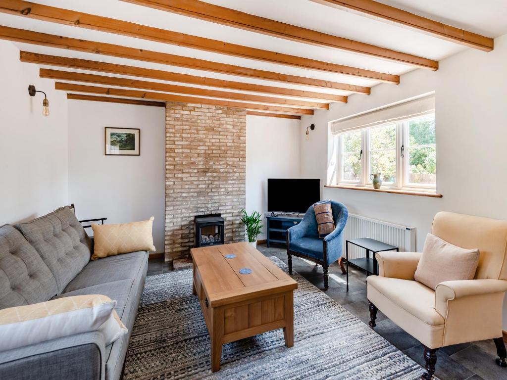 a living room with a couch and a table at The Pink Cottage in Bottisham