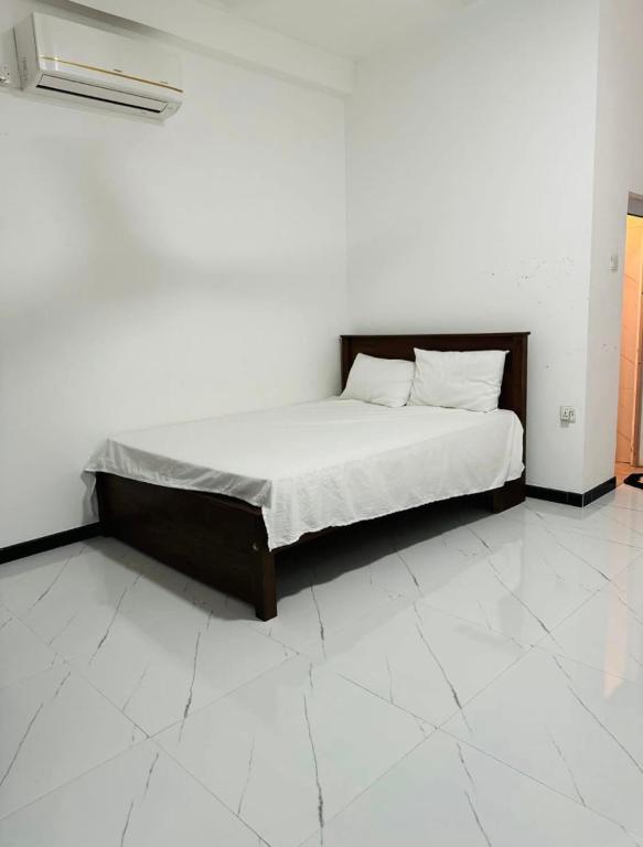 a bed in a room with a white floor at Sirisewana Holiday Inn in Ja-Ela