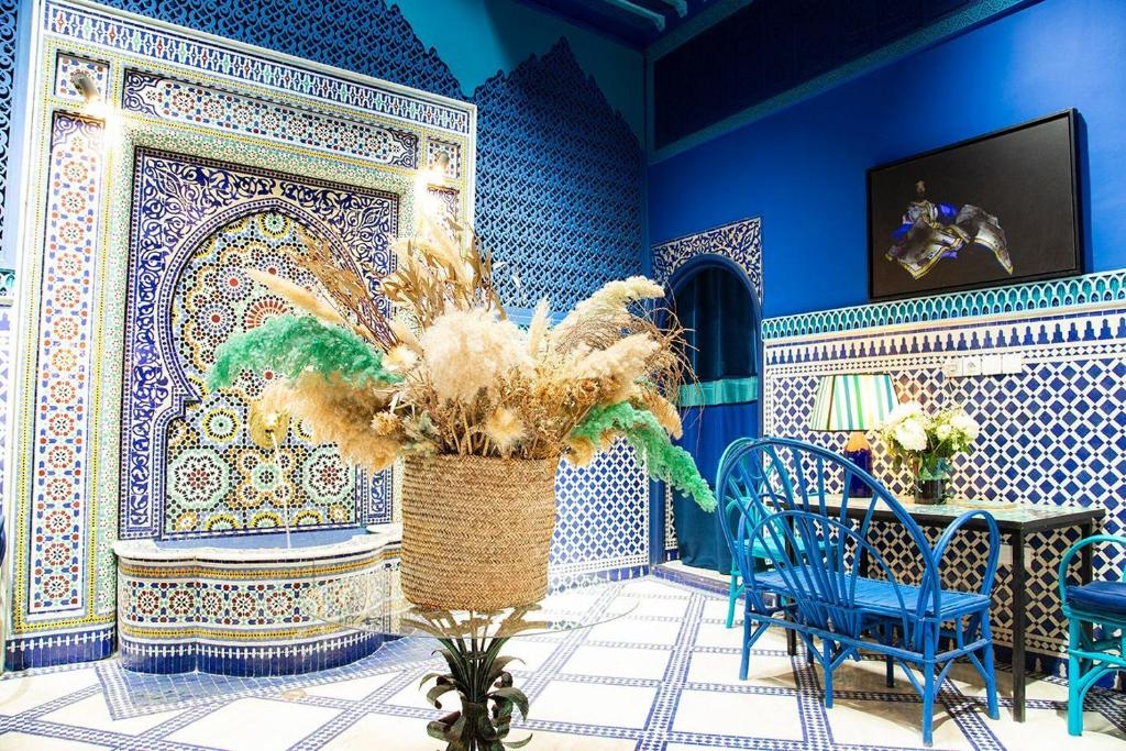 a blue room with a table and a vase with a plant at Riad & Spa Stella Cadente Marrakech in Marrakesh