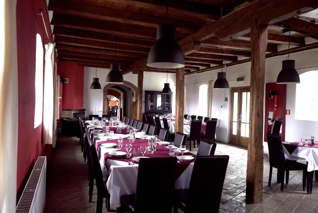una lunga sala da pranzo con tavoli, sedie e luci di Boutique Hotel Le Baron a Găneşti