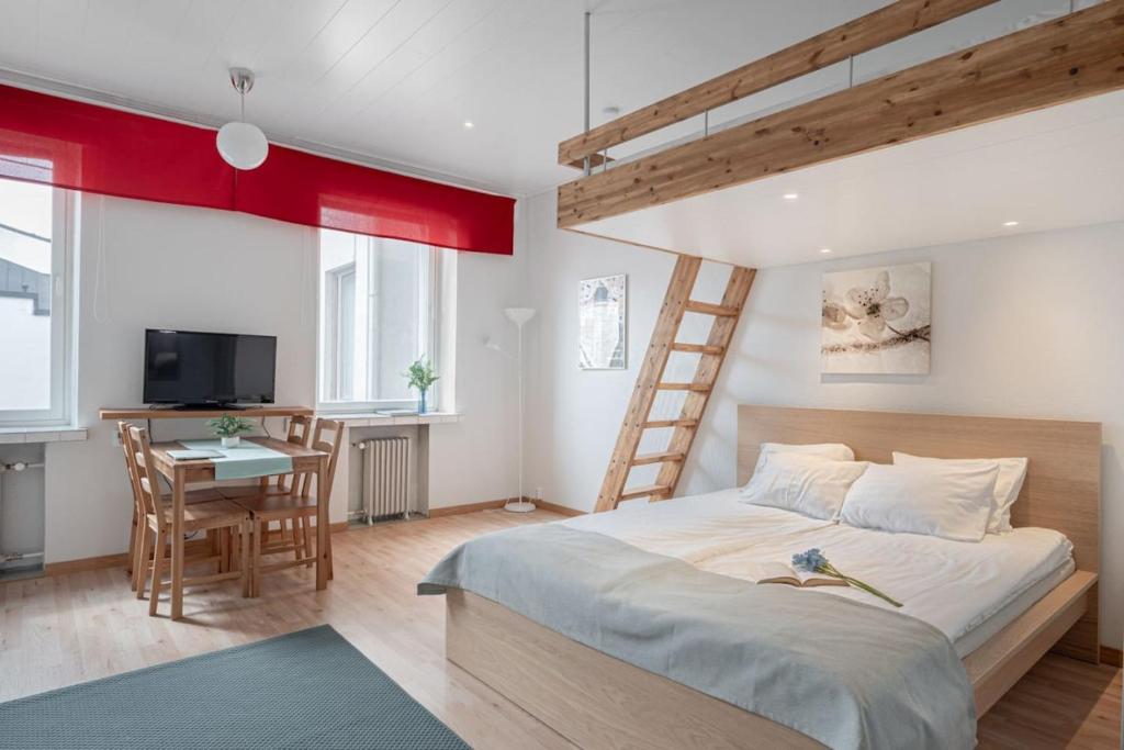 a bedroom with a bed and a desk and a ladder at Citykoti Downtown Studios in Helsinki