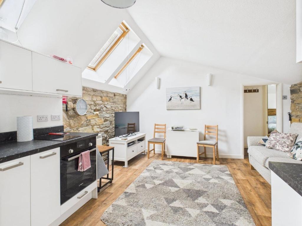a kitchen and living room with a couch and a table at 52a Albert Street in Kirkwall