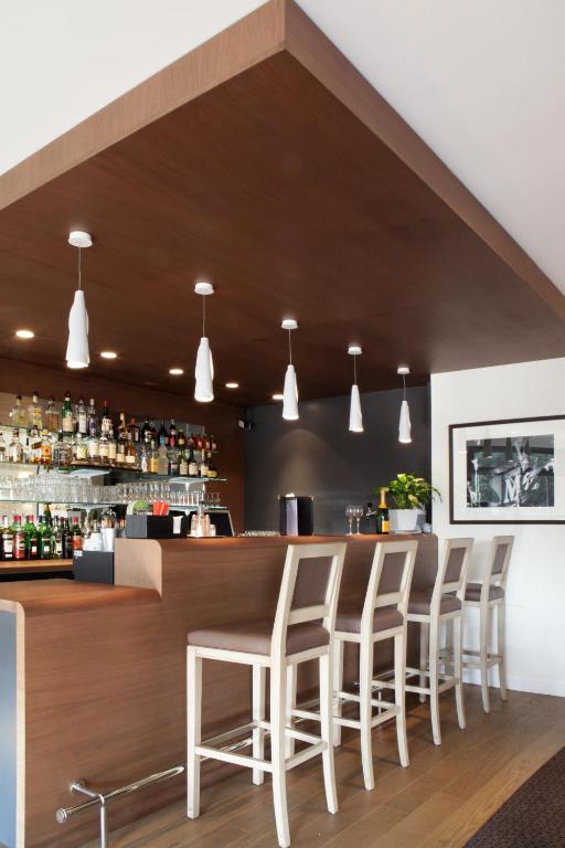 a bar with four stools in a restaurant at Best Western Plus Hostellerie Du Vallon in Trouville-sur-Mer