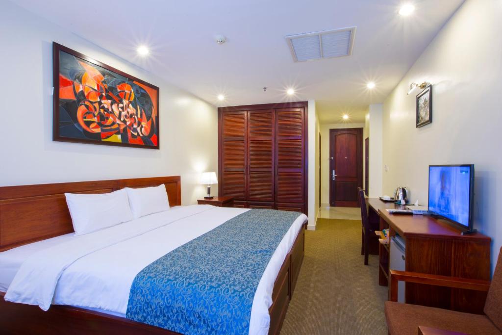 a bedroom with a bed and a desk and a television at Vientiane Plaza Hotel in Vientiane