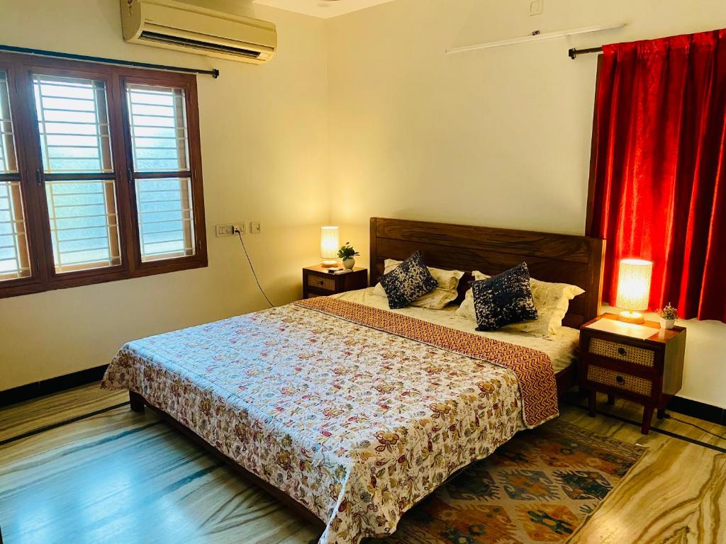 a bedroom with a bed and a red curtain at Sowkya Stays, Kakinada - Home Stay, Service Apartment, Vididhillu in Kākināda