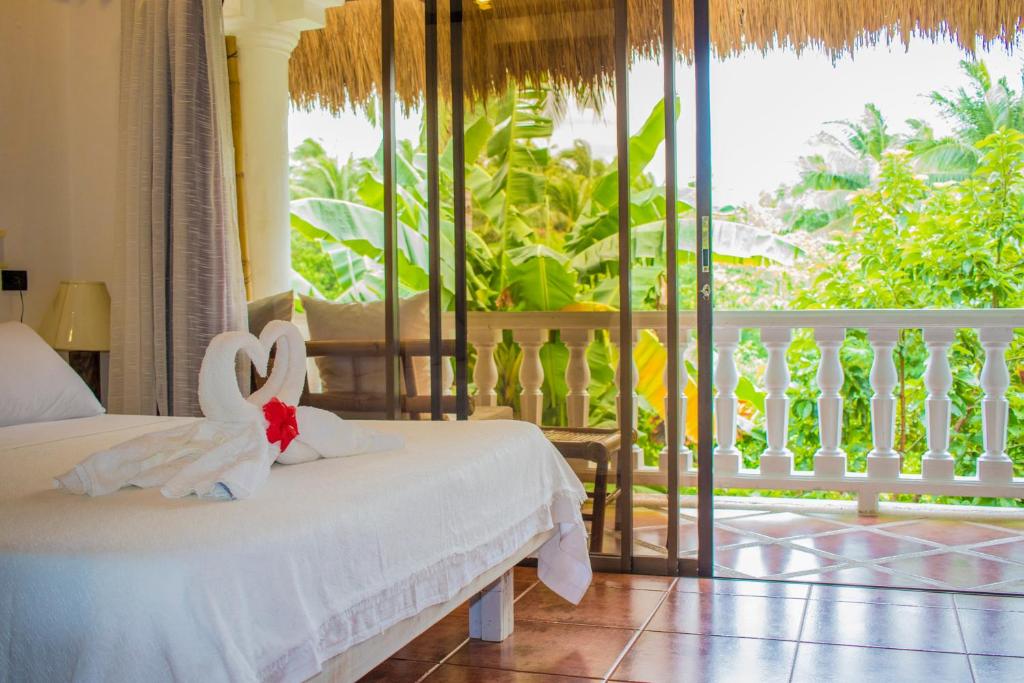 a bedroom with two beds and a balcony at Lanterna Hotel Boracay in Boracay