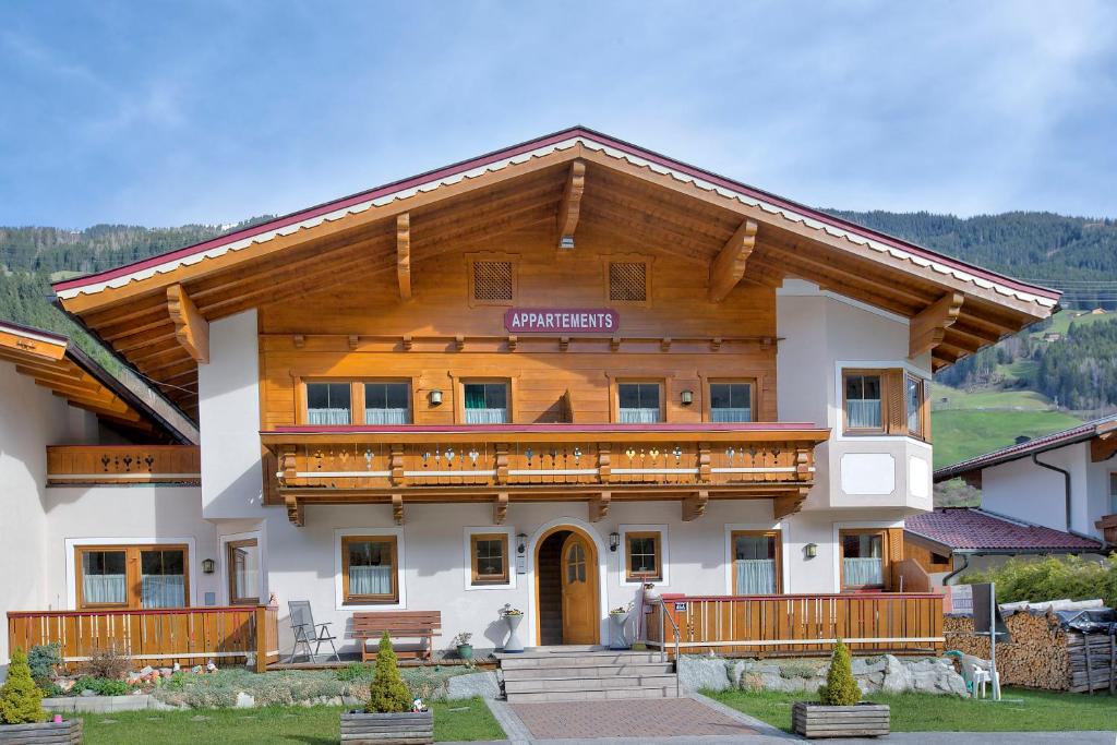 a large wooden house with a balcony at Apartment Bacher Nr.2 in Wald im Pinzgau