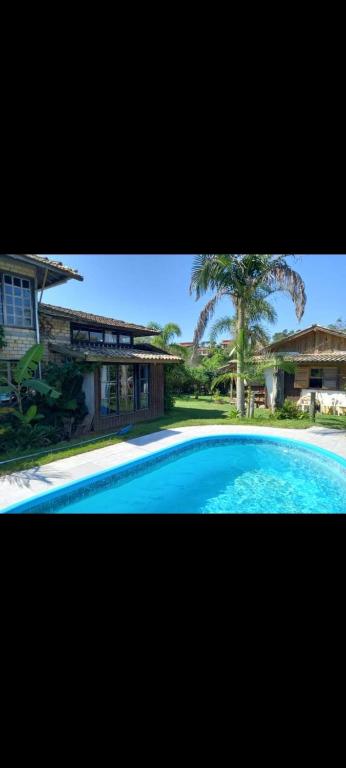a large blue swimming pool in front of a house at Portal de maria in Imbituba