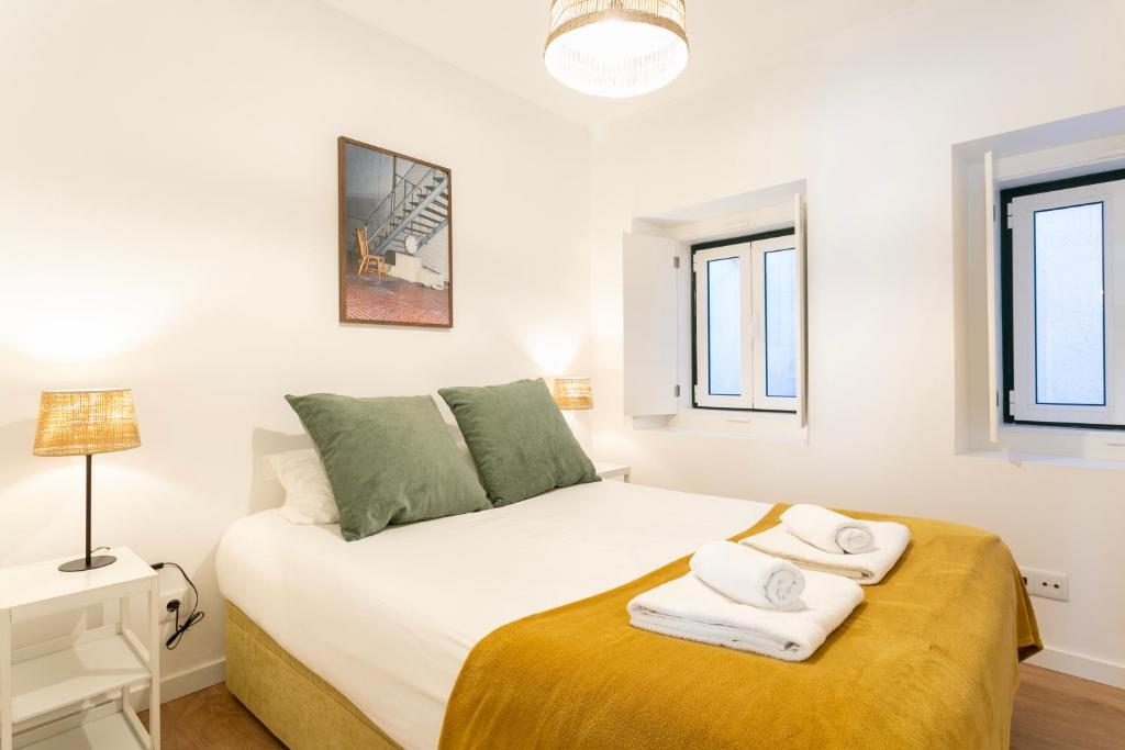 a bedroom with a bed with towels on it at Severa Apartments in Lisbon