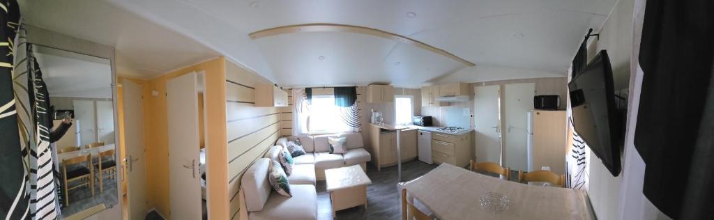 an interior view of a living room and kitchen in an rv at location mobile home proche de la mer in Hermanville-sur-Mer