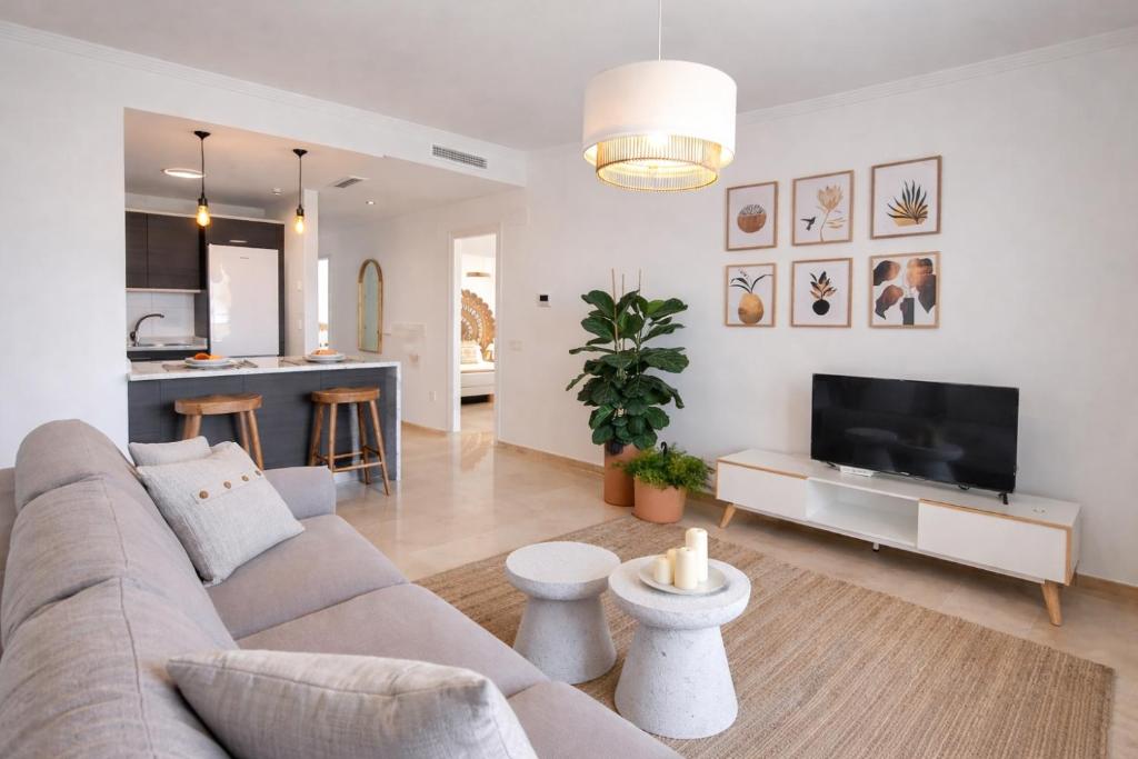 a living room with a couch and a flat screen tv at Noctua Manilva Sea View 023 in Manilva
