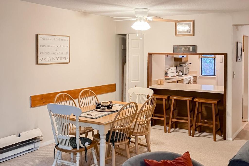 a living room with a table and chairs and a kitchen at Mad House in Waterville Valley