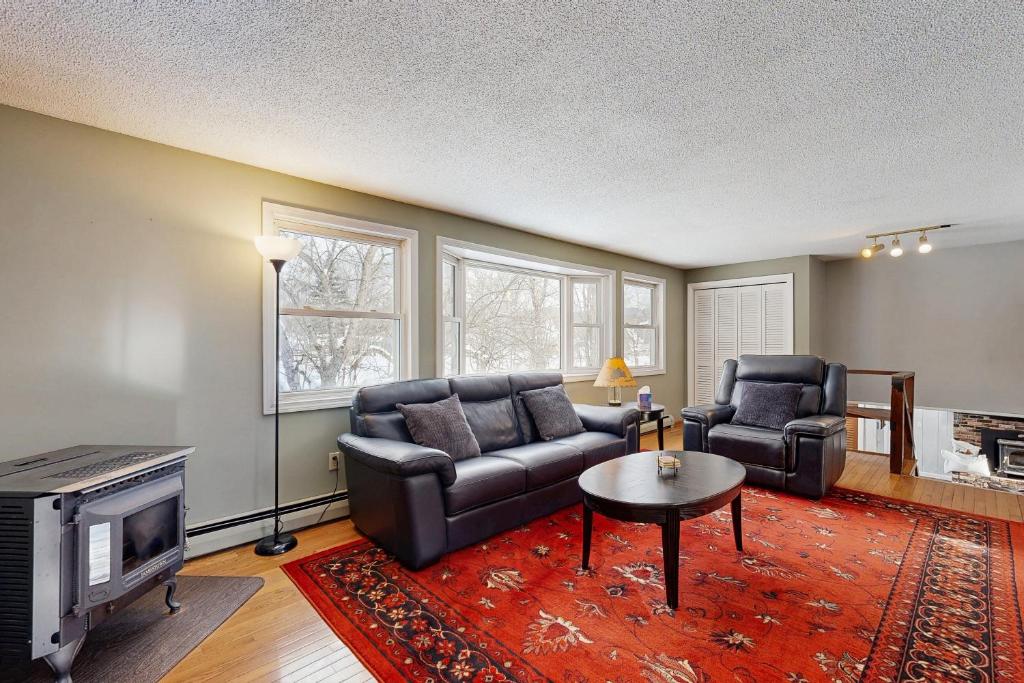 a living room with two leather chairs and a television at White Mountain Trailhead in Campton