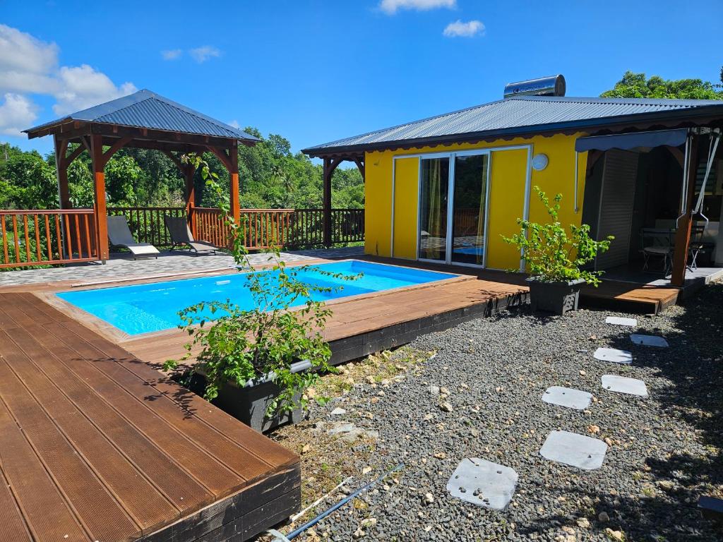 a tiny house with a pool and a deck at Bungalow Racoon Le Gosier in Le Gosier
