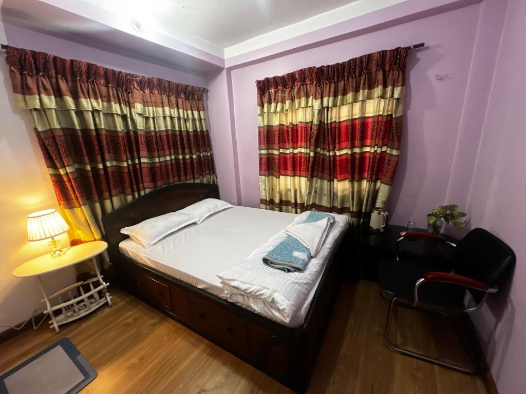 a small bedroom with a bed and a window at Kathmandu Valley View Homestay in Kathmandu