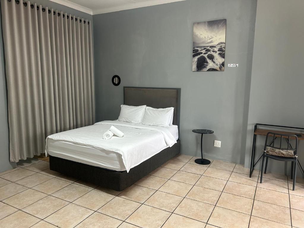a bedroom with a bed and a table in a room at Entire rental unit in Pretoria